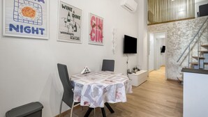 Ein Essbereich mit Tisch, Stühlen und Wandbildern.
