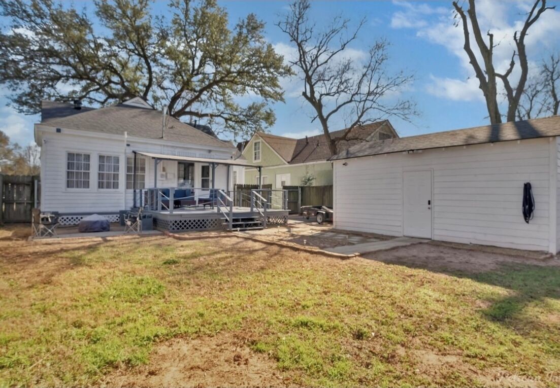 A residential property with a covered patio, a garage, and a fenced yard.