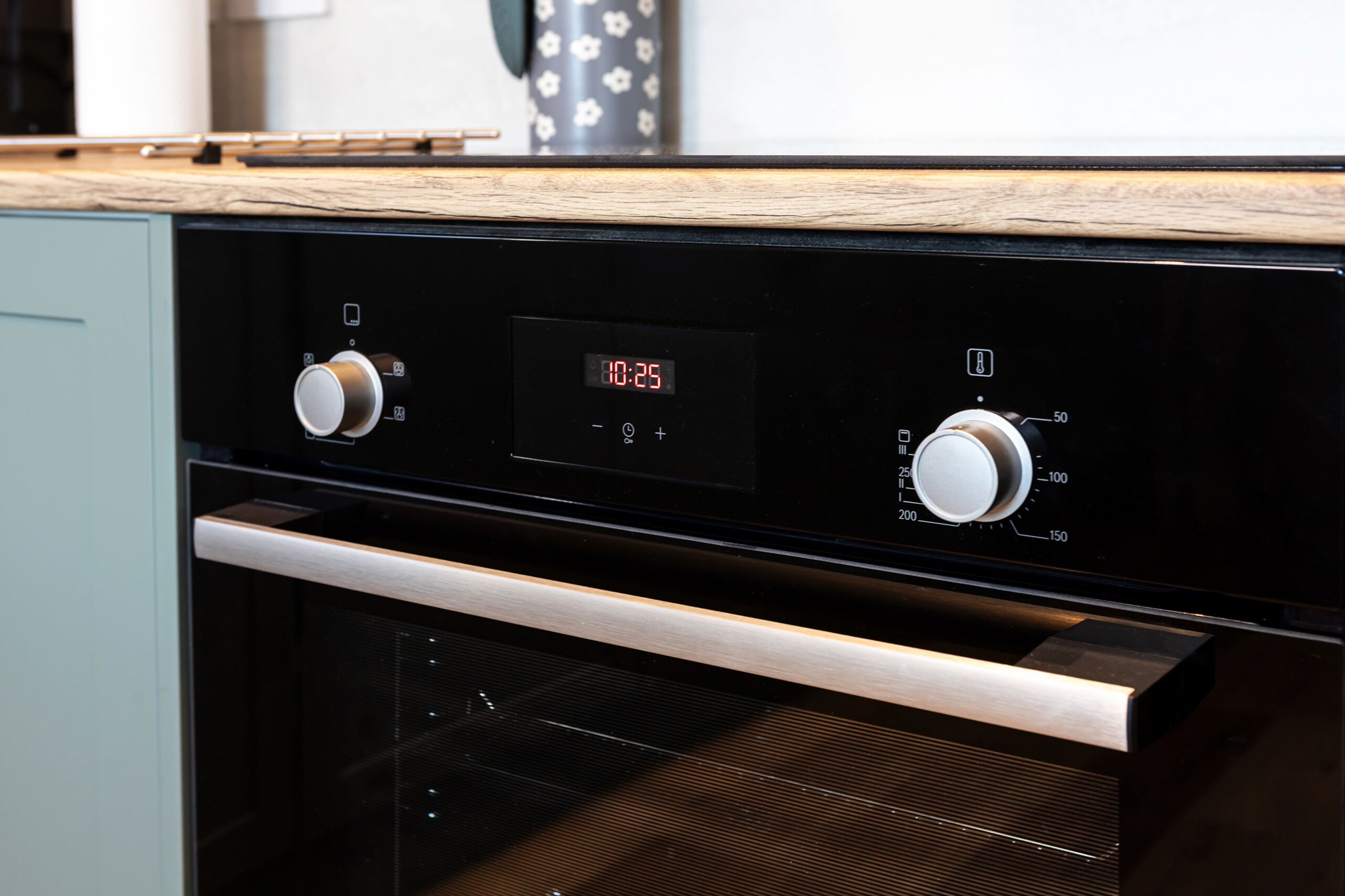 A modern kitchen with a built-in oven and two control knobs.