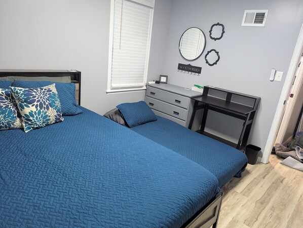 Un dormitorio con una cama grande, un escritorio y una cómoda.