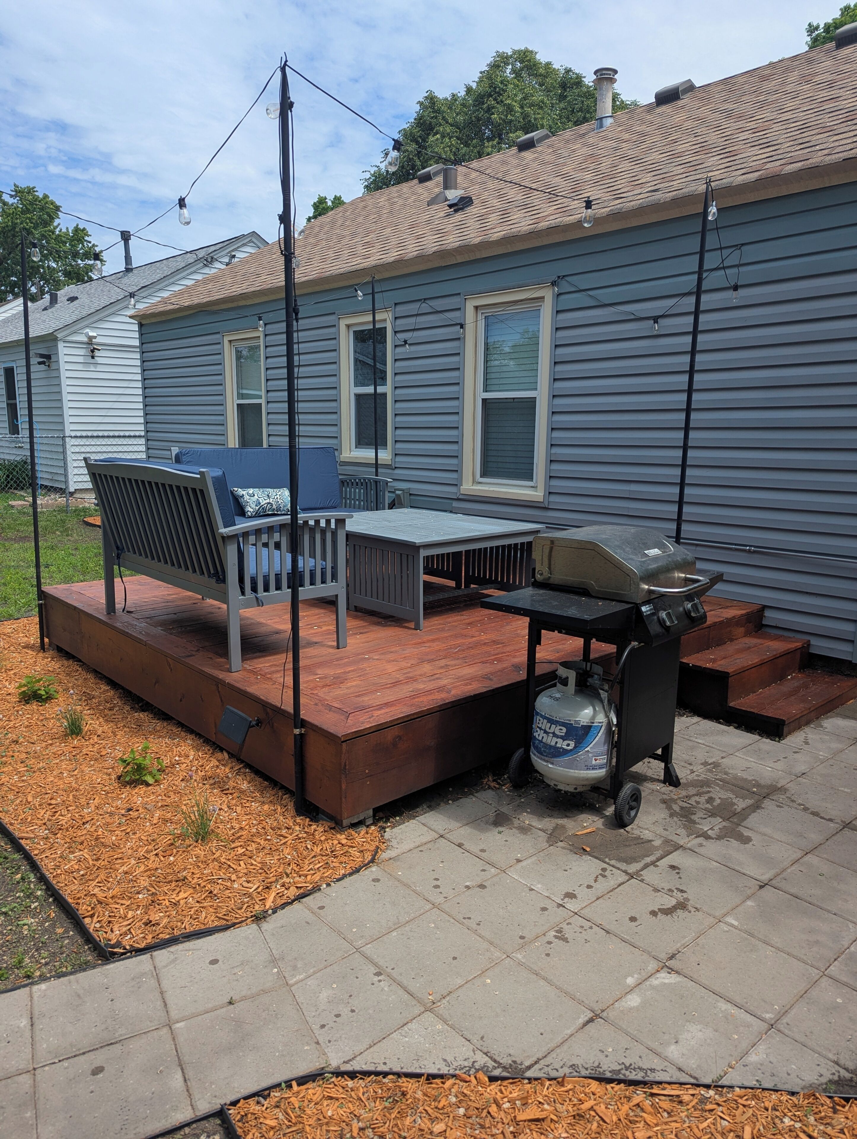 A patio with a grill, outdoor furniture, and a water dispenser.