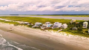 A coastal property with multiple houses, a beach, and a view of the ocean.