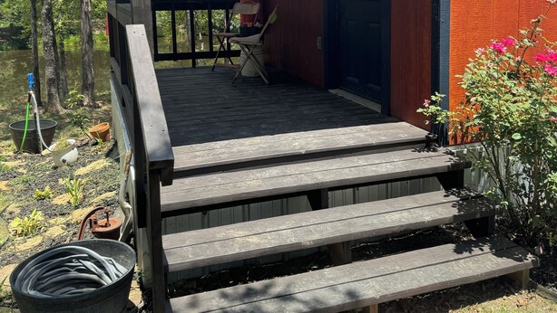 A wooden cabin with a porch, a welcome sign, and a small garden area. - Peaceful cabin retreat to enjoy all the quiet & beauty nature has to offer. (Mansfield)