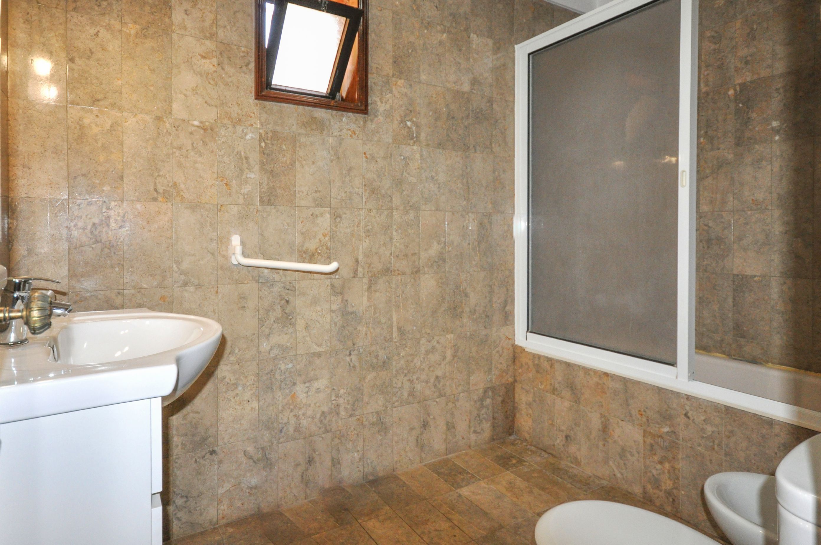 Une salle de bain comprenant un lavabo, des toilettes et un espace douche.