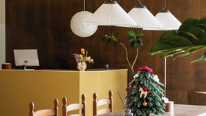 Un comedor con una mesa de madera, sillas y lámparas colgantes.