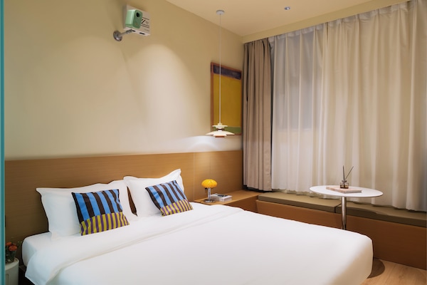 Cubrecamas, espacio para trabajar con laptop y cortinas blackout