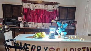 Una cocina con una isla central, microondas, tostadora y un lavabo.