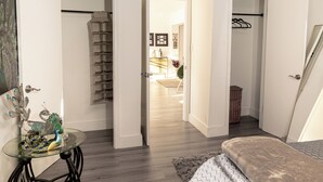 A bedroom with a bed, a glass table with decorative items, a wardrobe, and an open door leading to a bathroom. - Modern & Homely Entire House Orlando. Key Location! (Orlando)