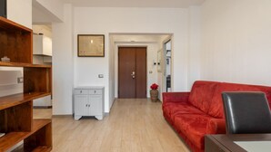A hallway with a wooden bench, a red sofa, and a white cabinet. - Ancient Roman Style - 7th Floor - Exclusive Apt (Roma)