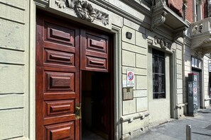 A building entrance with a large wooden door and a no parking sign. - Da Vinci - Exclusive Apartment - Navigli (Milano)
