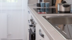 A modern kitchen with stainless steel appliances, a built-in oven, and a sink. - Humanitas - Exclusive Apartment (Rozzano)