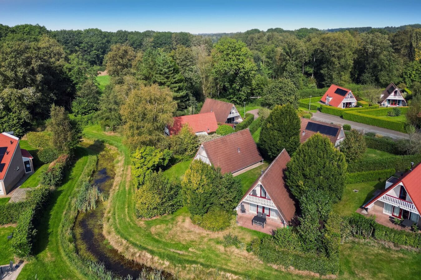 En landlig landsby med traditionelle huse, en snoet vej og en flod.