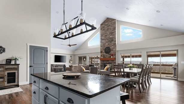 A spacious kitchen with a large island, a stone fireplace, and a dining area with a view. - Lake Escape: Views, Hot Tub, Game Room & Pools (Hollister)