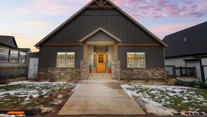 A two-story house with a stone facade and a dark roof. - Lake Escape: Views, Hot Tub, Game Room & Pools (Hollister)