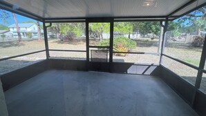 Una habitación amplia y de concepto abierto, con piso de concreto y techo con líneas horizontales.