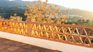 A brick wall with a metal fence overlooking a valley with buildings and mountains. - Complex of 2 houses with swimming pool, (Melegís)