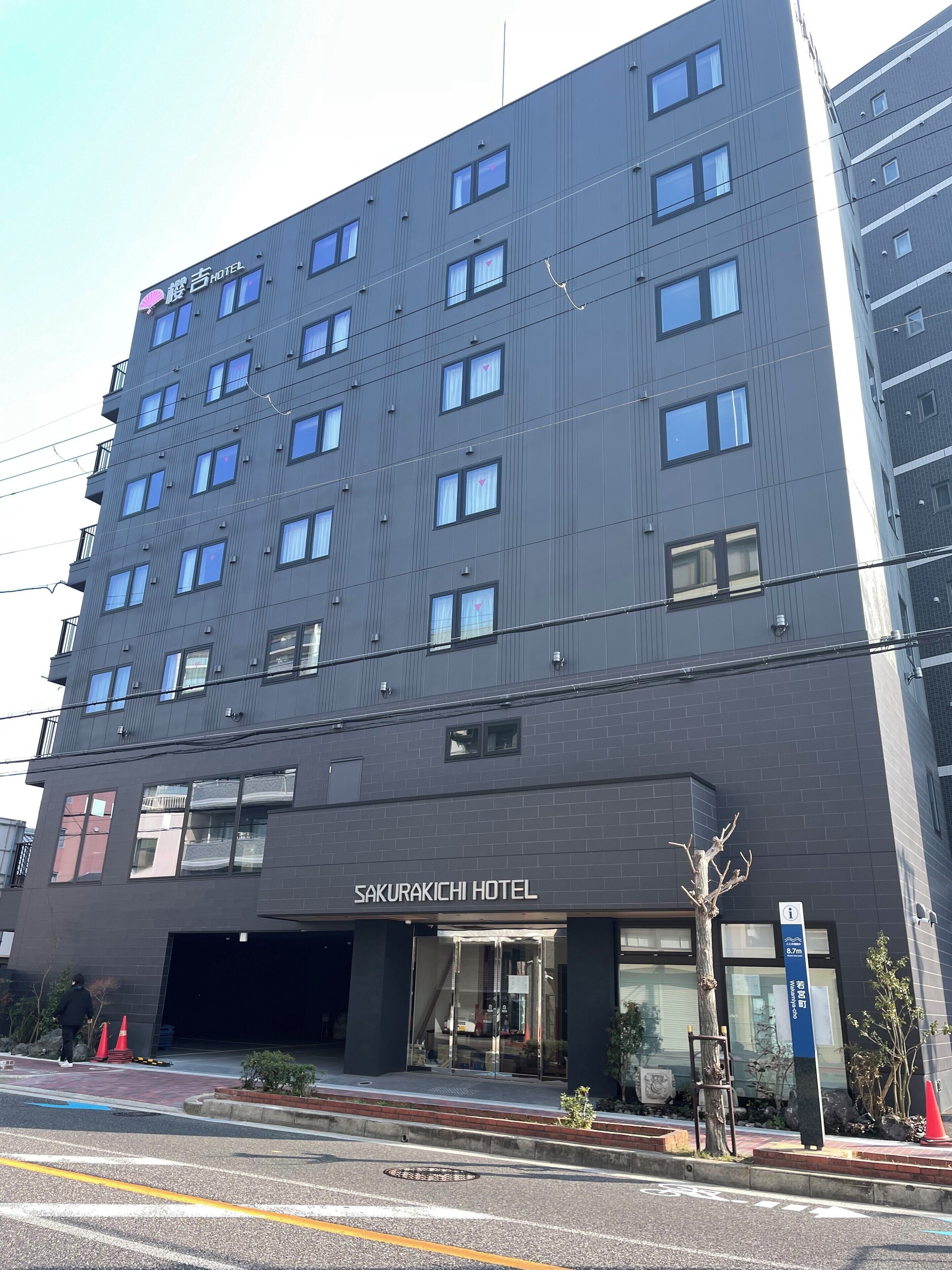 A modern building with multiple floors, a prominent entrance, and a sign indicating it is the Sakurakichi Hotel.