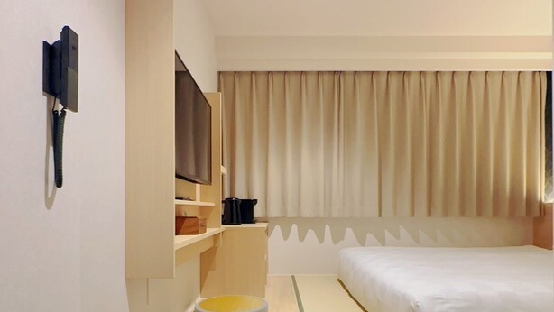 A hotel room with a bed, a TV, a coffee maker, and a small table. - SAKURAKICHI HOTEL (Izumisano)