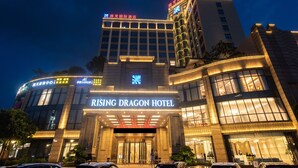 A modern hotel with illuminated signage, large windows, and a prominent entrance. - Rising Dragon International Hotel (Dongguan)