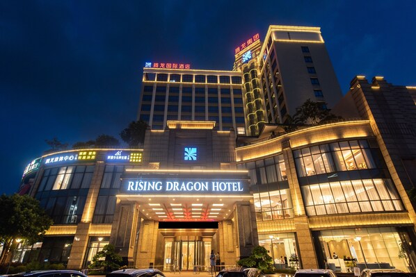 A modern hotel with illuminated signage, large windows, and a prominent entrance.