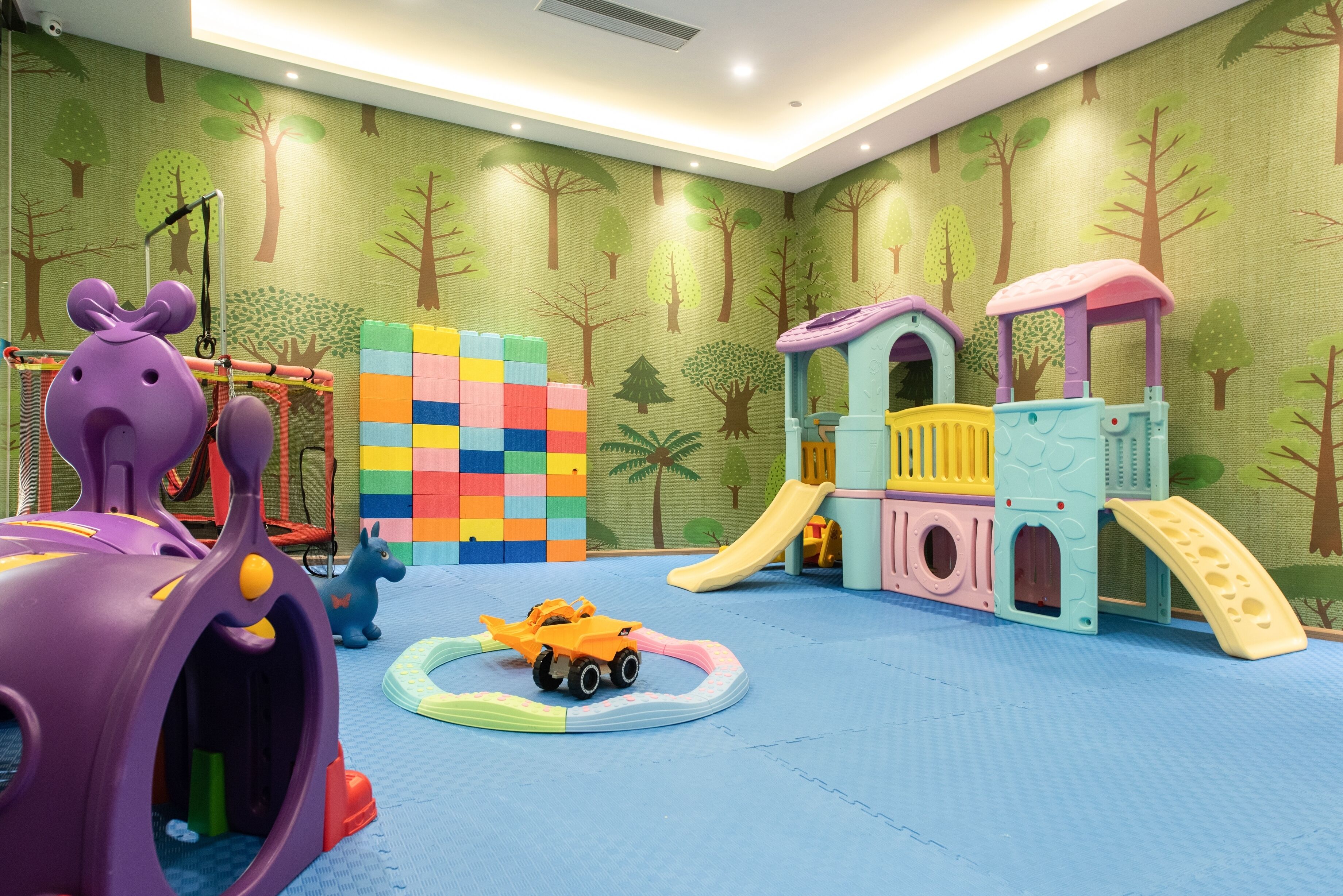 A children's play area with a slide, climbing structures, and a tunnel.