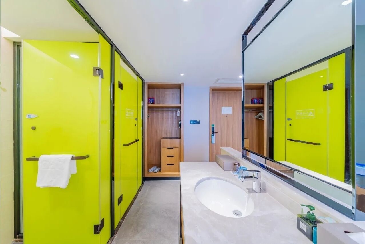 A modern bathroom with bright yellow lockers, a large mirror, and a white sink.