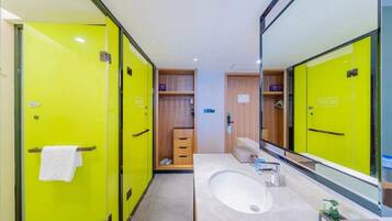 A modern bathroom with bright yellow lockers, a large mirror, and a white sink.