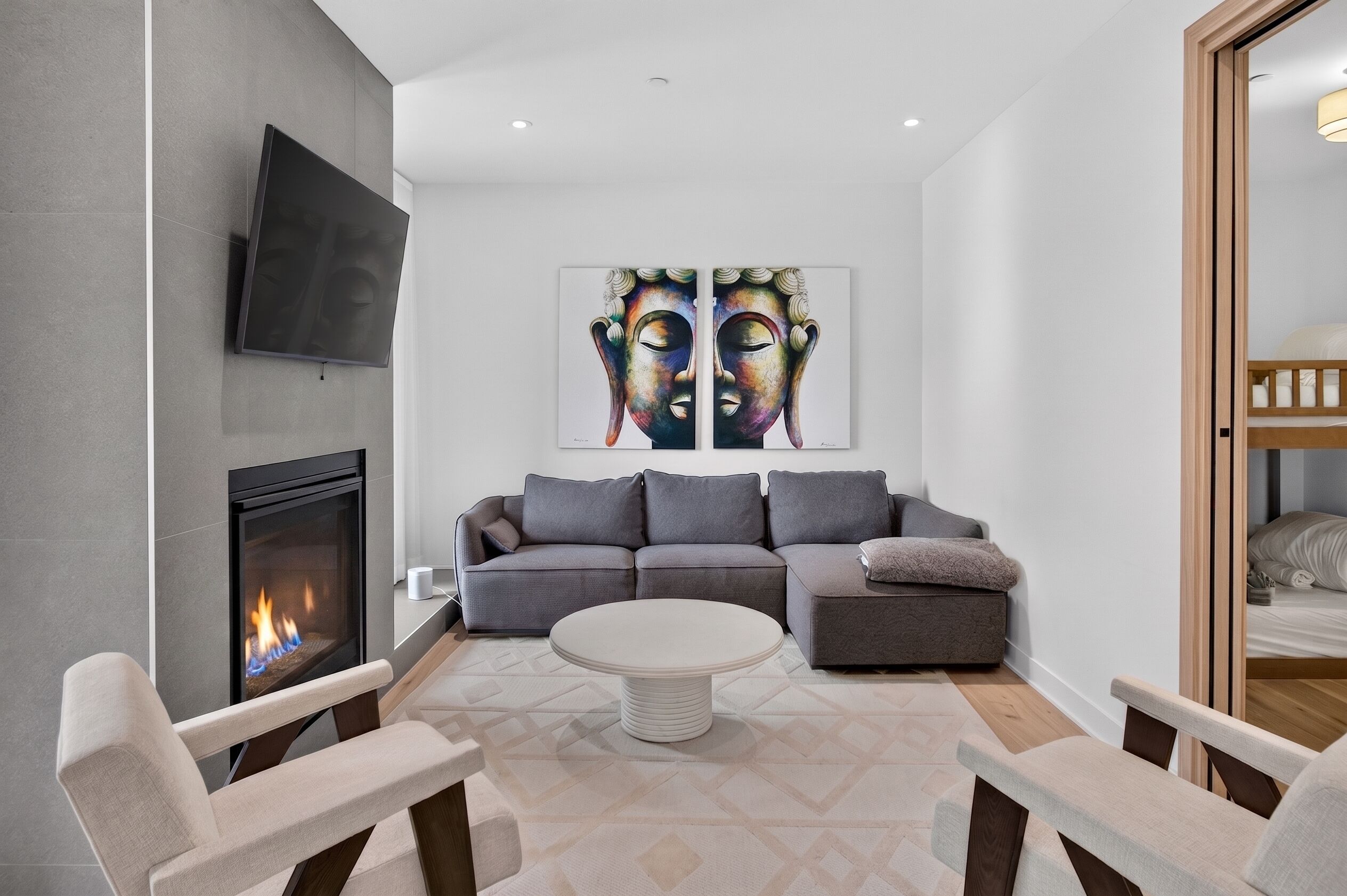 A modern living room with a fireplace, a sofa set, a coffee table, and a painting on the wall.