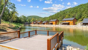 Un hôtel situé au bord d’un lac, doté de chalets en bois, d’une terrasse en bois et d’un sentier pavé de pierres.
