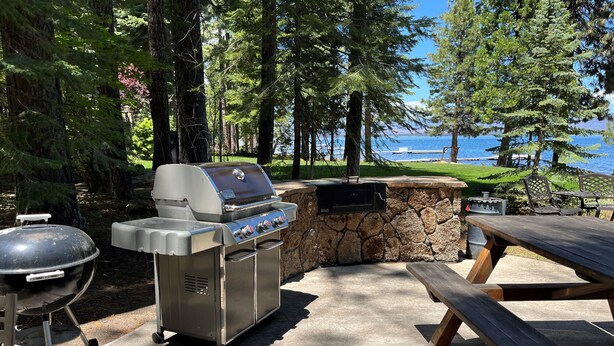 Un espace extérieur aménagé avec un barbecue, un mur en pierre, un gril et une table de pique-nique.