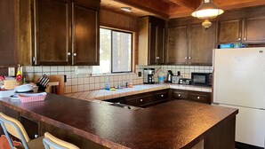 Une cuisine avec des meubles en bois, un grand îlot central et une fenêtre.