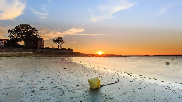 A beach with a sunset, a yellow buoy, and a building in the background. - 2 bedroom awesome home in Saint Lyphard (Saint Lyphard)