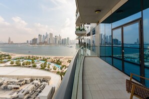 A balcony with a view of a city skyline and a beach.