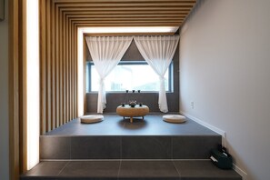 A modern bathroom with a built-in bench, a window with sheer curtains, and a view of the outdoors. - Run to you fullvilla (Gyeongju)