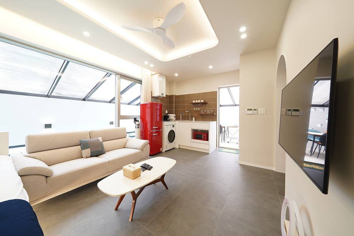 A modern living room with a sofa, coffee table, and a TV mounted on the wall.