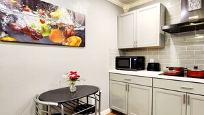 A kitchen with white cabinets, a black microwave, and a red pot on the counter. - FREE NIGHT! TV In Bedroom, Patio, Private  (Houston)