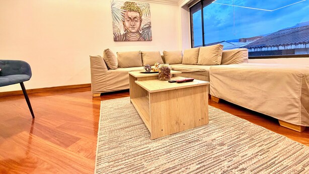 Ein modernes Wohnzimmer mit einer Couch, einem Couchtisch und einem Bild an der Wand.