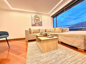 Ein modernes Wohnzimmer mit einer Couch, einem Couchtisch und einem Bild an der Wand.