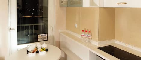 Una cocina compacta con una mesa blanca, un lavabo y una estufa.