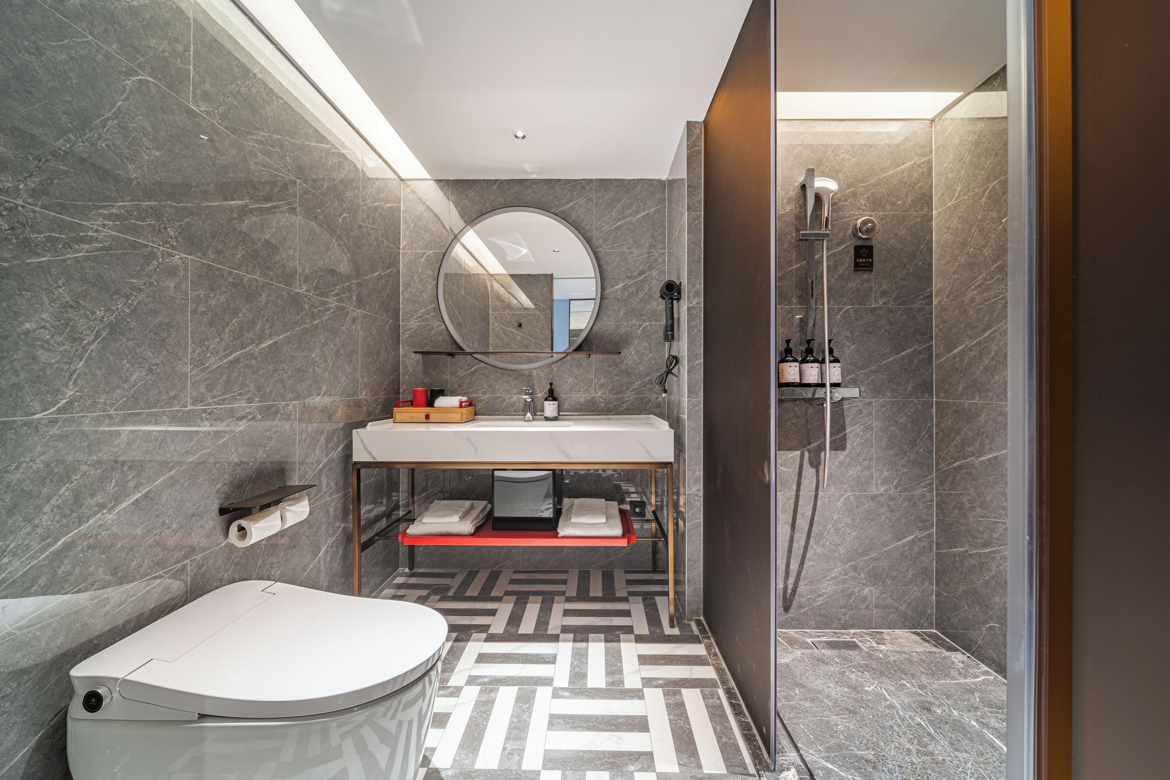 Une salle de bain moderne équipée de toilettes, d’un lavabo et d’une douche.