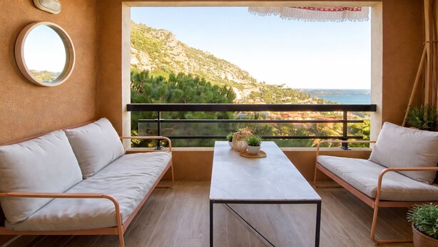 A balcony with two sofas and a table, overlooking a coastal landscape with trees and a view of the sea. - T2, swimming pool, Tennis MC (Beausoleil)