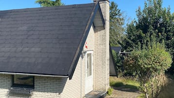 A house with a sloped roof and a brick chimney.