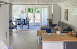 A cozy living room with a sofa, a dining table, and a kitchen area.