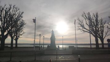 A statue in a park with bare trees and lampposts.