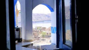 A room with a large window overlooking a mountainous landscape.