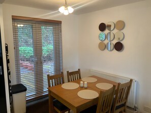 Enjoy meals in this dining area with a table for four and matching chairs, set against a wall with a decorative mirror arrangement.