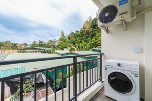 Ein Balkon mit Waschmaschine und Klimaanlage.