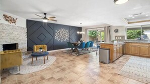 Una cocina moderna con comedor, chimenea y ventilador de techo.