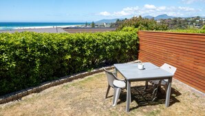 A patio with a table and chairs overlooking a beach. - Etosha Villa @ Blue Seas (Scamander)