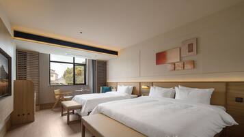 A modern hotel room with two beds, a bench, a desk, and a large window.